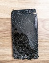 Top view cracked broken mobile screen glass on the wooden floor Royalty Free Stock Photo