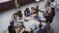 Top view of creative business team working at modern office. Colleagues talking, smiling, high five with each other. Royalty Free Stock Photo