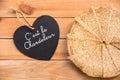 Top view of crepes french pancakes text c`est la chandeleur in a heart, rustic wood background