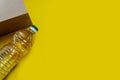 Top view of the crisis stock of food products.A paper bag and a bottle of sunflower oil on a yellow isolated background Food