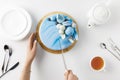 top view of cropped hands slicing cake on chopping board