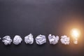 Top view crumpled paper and light bulbs on black stone board. Cr Royalty Free Stock Photo