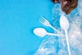 Top view of crushed plastic spoons, forks and cups as a disposable waste with copy space on bright blue background Royalty Free Stock Photo