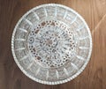 Top view of a crystal vase on the crocheted lace coaster on a wooden table