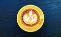 Top view of cup of art cappuccino or latte coffee on dark blue wooden background. Royalty Free Stock Photo