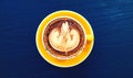 Top view of cup of art cappuccino or latte coffee on dark blue wooden background in vintage tone. Royalty Free Stock Photo