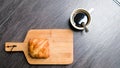 Top view cup of Black coffee and croissant bread on wooden board background, coffee break refresh relaxation time Royalty Free Stock Photo