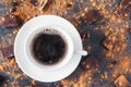 Top view cup of black coffee on a dark stone background with beans, cocoa powder and chocolate pieces scattered around. Selective Royalty Free Stock Photo