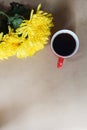 Yellow flowers and a cup of coffee, red coffee mug Royalty Free Stock Photo