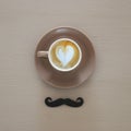 top view of cup of coffee and black mustache over wooden background. Royalty Free Stock Photo