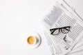 top view of cup of coffee and eyeglasses on newspapers, on white table Royalty Free Stock Photo