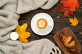 Top view of a cup of coffee, fresh croissant, candle, colorful maple leaves and knitted plaid on the wooden table. Autumn flat lay Royalty Free Stock Photo