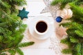 Top view of a cup of coffee / hot chocolate, fir branches, gold Christmas decorations, stars, balls on a shabby white wooden Royalty Free Stock Photo