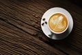 Top view of a cup of coffee latte tree shape and coffee beans on old wooden background Royalty Free Stock Photo