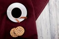top view cup of coffee on the left with cinnamon cookies with filling and copy space on white wooden background