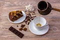 Top view of a cup of coffee and a piece of delicious cake on a saucer, coffee beans, a bowl with sugar cubes, chocolate bar and an Royalty Free Stock Photo