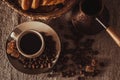 Top view cup of coffee on textile with beans, dark candy sugar, pot, basket and cake Royalty Free Stock Photo
