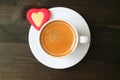 Top View of a Cup of Espresso Coffee with Red Heart Shaped Cookie on Dark Brown Wooden Table Royalty Free Stock Photo