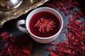 top view of a cup of hibiscus tea with dried petals scattered around Royalty Free Stock Photo
