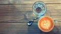 Top view cup of hot art latte coffee and glass of water with copy space in vintage color style. Royalty Free Stock Photo