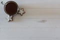 Top view of cup with hot chocolate and coookies on white wooden table with copy space