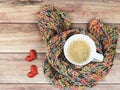 Top view of cup of latte coffee  wrap in colorful scarf and two red glitter hearts on wooden table Royalty Free Stock Photo