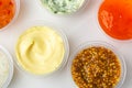 Top view on cups of various sauces and condiments on white background