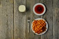 Top view of curd waffles on a plate, apricot jam, a glass of milk and a fork on a wooden table Royalty Free Stock Photo