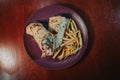 Top view of a cut delicious wrap with meat and salad on a plate with french fries Royalty Free Stock Photo