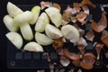 Top view of cut in half peeled onion and peels on the black background Royalty Free Stock Photo