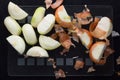 Top view of cut in half unpeeled and peeled onion on t heblack background Royalty Free Stock Photo