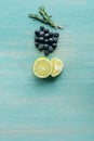 Top view of cut lemons, blueberries and rosemary on blue textured surface. Royalty Free Stock Photo