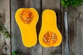 Top view Cut ripe orange pumpkin with seeds and herbs on the rustic wooden table. Vegetarian, vegan, healthy diet food. Autumn har