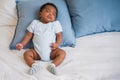 Top view of cute African American infant baby boy sleeping alone on the bed for relaxing and healthcare in the bedroom at home Royalty Free Stock Photo