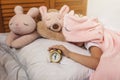 Top view of cute awaking girl with her toy animals wearing in light pink pajama with unicorn hoody Royalty Free Stock Photo