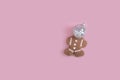 Top view of a cute bear cookie with a reflective ball on a pink background