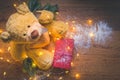 View of a teddy with a red wrapped present, and Christmas decorations on wooden background Royalty Free Stock Photo