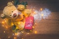 View of a teddy with a red wrapped present, and Christmas decorations on wooden background Royalty Free Stock Photo