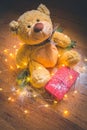 View of a teddy with a red wrapped present, and Christmas decorations on wooden background Royalty Free Stock Photo