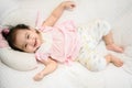 Top view of cute happy Asian baby girl lying on the bed, smiling and cheerful face, looking at the camera Royalty Free Stock Photo