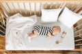 Cute infant baby napping on his side in wooden cot Royalty Free Stock Photo