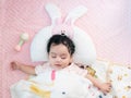 Top view of a cute little Asian baby girl wrapped in a blanket sleeping on bed Royalty Free Stock Photo