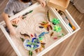 Top view cute little baby boy playing sensory box dinosaur world with kinetic sand table