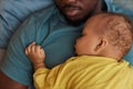 Top view cute little baby sleeping on fathers chest at naptime