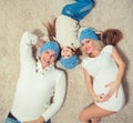 Top view of cute little girl and her beautiful young parents looking at camera and smiling while lying on the floor at Royalty Free Stock Photo