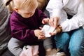 Top view of cute little girl toddler sitting on sofa, holding white box. Doctor showing preparing digital thermometer. Royalty Free Stock Photo