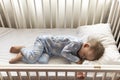 top view Cute little 2-3 years preschool baby boy kid sleeping sweetly in white crib during lunch rest time in blue Royalty Free Stock Photo