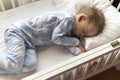 top view Cute little 2-3 years preschool baby boy kid sleeping sweetly in white crib during lunch rest time in blue Royalty Free Stock Photo