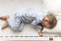 top view Cute little 2-3 years preschool baby boy kid sleeping sweetly in white crib during lunch rest time in blue Royalty Free Stock Photo