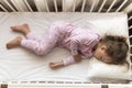 top view Cute little 3-4 years preschool baby girl kid sleeping sweetly in white crib during lunch rest time in pink Royalty Free Stock Photo